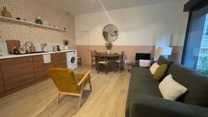 a living room with a green couch and a kitchen at Quiet and central, 6p fully equipped in Arras +19 photos