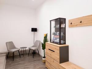 a room with two chairs and a cabinet and a table at Wolkenfuchs 111qm - City Nähe DUS & Essen & Köln - familienfreundlich - 10 Personen - 3 Bedrooms in Wuppertal