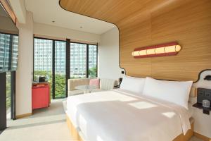 a bedroom with a large white bed and large windows at The Standard, Singapore in Singapore