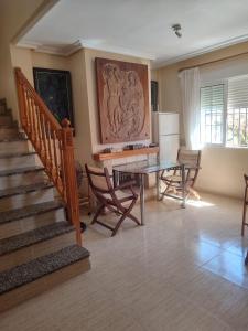 un soggiorno con tavolo, sedie e scala di Chalet de 8 camas a Orihuela Costa