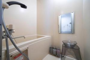 a bathroom with a bath tub and a mirror at Silk Court 403 in Chitose +47 photos
