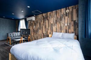 a bedroom with a large white bed and a couch at Silk Court 403 in Chitose