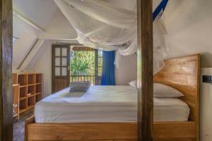 ein Schlafzimmer mit einem Bett und einem Laptop darauf in der Unterkunft Villa Kupu-Kupu, private pool & lush garden in Gili Air + 16 Fotos