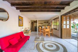 ein Wohnzimmer mit einem roten Sofa und einem Tisch in der Unterkunft Villa Kupu-Kupu, private pool & lush garden in Gili Air