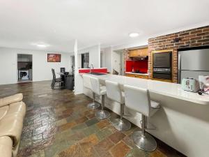 a kitchen with a bar with chairs and a couch at MetaWise Cozy Family Room in Shared Home Free Parking in Castle Hill