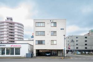 a tall white building with a parking lot at Silk Court 403 in Chitose