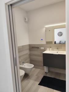 a bathroom with two sinks and a toilet and a mirror at Maison 40 in Albiano +37 photos