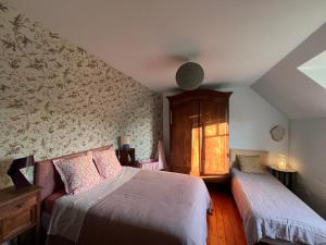 a bedroom with two beds and a window at maison proche bourg et plages 7 personnes jardin Ker Emmanuel in Erquy