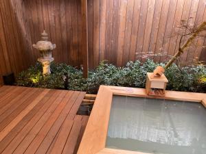 ein Hinterhof mit Swimmingpool und Vogelbad in der Unterkunft Kinnotake Saryo in Hakone