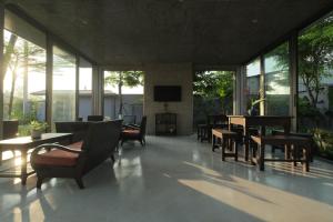 a living room with chairs and a table and a television at Sea to Sea Villa Boutique in Hue