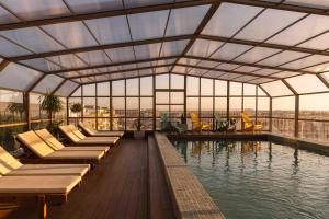 a building with a pool with chairs and water at Upon Vila - Alcochete Hotel in Alcochete