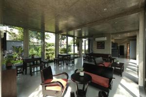 a living room with tables and chairs and windows at Sea to Sea Villa Boutique in Hue