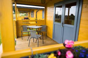a table and chairs on the porch of a tiny house at Chatičky Centrum Pastvinská přehrada in Nekoř