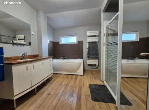 a large bathroom with two sinks and two tubs at La Quarantaine in Quarante