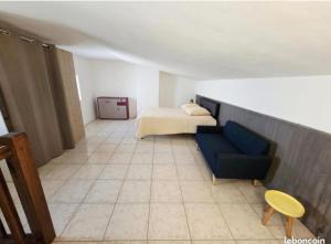 a room with a bed and a blue couch at La Quarantaine in Quarante
