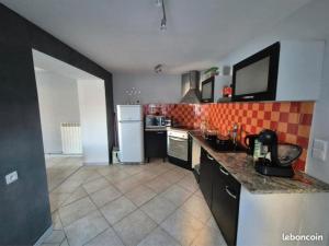 a kitchen with a white refrigerator and a tile floor at La Quarantaine in Quarante