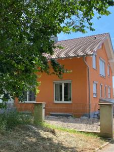 a house with a fence in front of it at Ferienwohnung im Sand in Herbolzheim