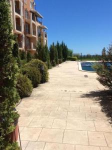 ein leerer Bürgersteig neben einem Gebäude mit einem Swimmingpool in der Unterkunft Апартамент Бяла in Byala