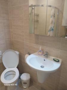 a bathroom with a toilet and a sink at Апартамент Бяла in Byala +7 photos