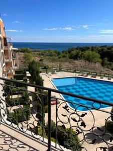 einen Balkon mit Poolblick in der Unterkunft Апартамент Бяла in Byala
