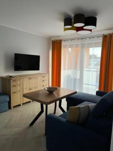 a living room with a table and a tv at La Marina in Władysławowo