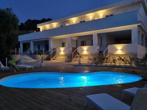 a villa with a swimming pool in front of a house at Le Fronde Vieste in Vieste