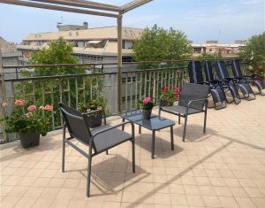 a row of chairs and tables on a balcony at Attico Centrale Ostia 20 in Lido di Ostia +11 photos