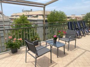 a row of chairs and tables on a balcony at Attico Centrale Ostia 20 in Lido di Ostia