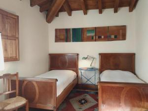 a bedroom with two beds and a lamp on a table at La Casuca de Margot in Agüero