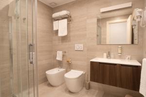 a bathroom with a toilet and a sink and a shower at Spazio Mari in Terracina +53 photos