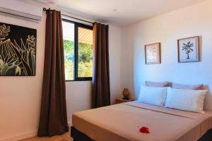a bedroom with a large bed with a window at Villa Lagoon Paradise in Haapiti