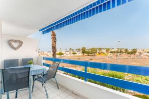 a balcony with a table and chairs and a view of the desert at Apartment In Playa Flamenca in Playa Flamenca
