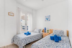 a bedroom with two beds with blue pillows at Apartment In Playa Flamenca in Playa Flamenca +16 photos