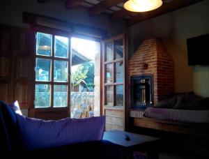a living room with a brick fireplace and a couch at La Casuca de Margot in Agüero