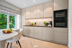 a kitchen with white cabinets and a table and a window at Maybach Suite Westerland auf Sylt in Westerland