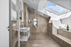 a bathroom with a sink and a skylight at Maybach Suite Westerland auf Sylt in Westerland