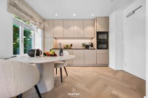 a kitchen with a white table and a counter top at Maybach Suite Westerland auf Sylt in Westerland +38 photos
