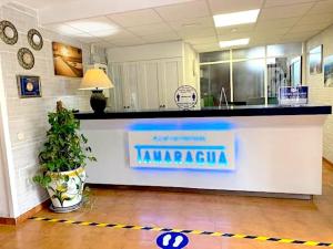 a lobby with a counter with a sign on it at Apartamentos Tamaragua in Playa del Ingles