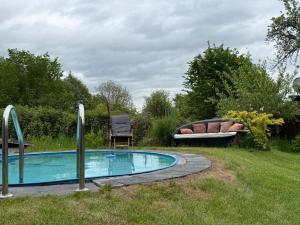 OderbergにあるFerienhaus Garten und Pool Ferienwohnung und Gästehausの庭に椅子とベンチが置かれた小さなプール