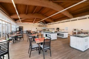 a restaurant with wooden ceilings and tables and chairs at AluaSun Mediterráneo in S'Algar