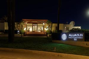 a sign in front of a house at night at AluaSun Mediterráneo in S'Algar