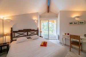 een slaapkamer met een groot wit bed en een bureau bij Lagrange Vacances - Eden Parc Golf in Lacanau-Océan +108 foto's
