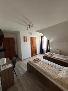 A bed or beds in a room at Penzión Nezábudka