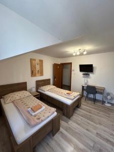 A bed or beds in a room at Penzión Nezábudka