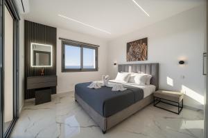 ein Schlafzimmer mit einem großen Bett und einem Spiegel in der Unterkunft HiddenGems Residences 202 - The LXR Penthouse - Pool & Beach Steps in Paphos City