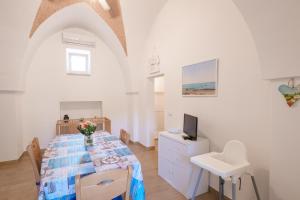 een witte kamer met een tafel en een wastafel bij Villa della Nonna in Torre Canne
