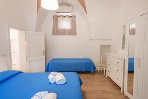 twee bedden in een kamer met blauwe lakens bij Villa della Nonna in Torre Canne
