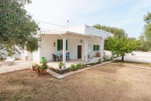 een klein wit huis met een patio bij Villa della Nonna in Torre Canne