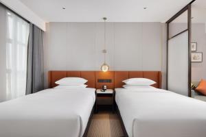 Postel nebo postele na pokoji v ubytování Hilton Garden Inn Xingyi Orange Hill Plaza