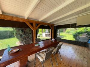 OderbergにあるFerienhaus Garten und Pool Ferienwohnung und Gästehausの大きな窓のある部屋(大きな木製テーブル付)